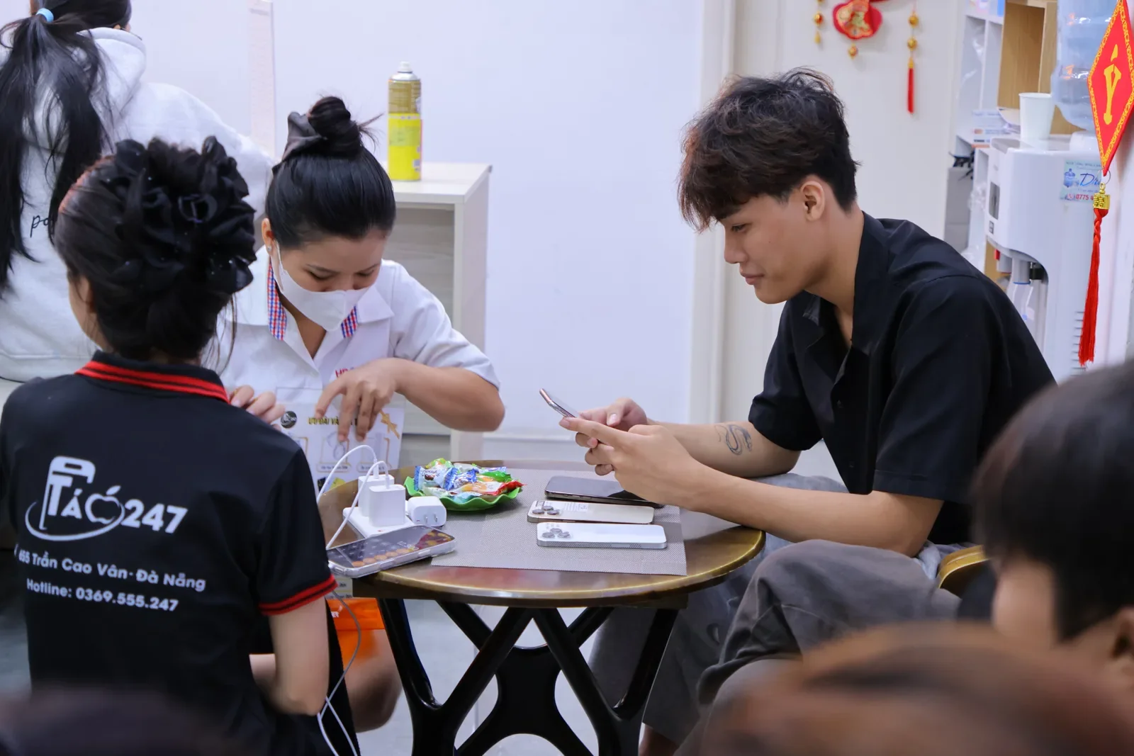 Nhân viên và kỹ thuật viên Táo 247 cùng xử lý máy cho khách nam