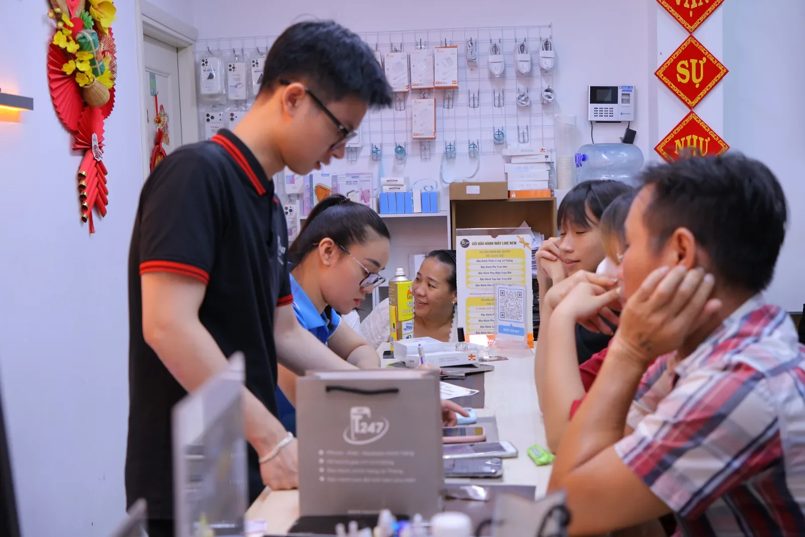 Nhân viên kỹ thuật Táo 247 xử lý máy cho khách tại bàn